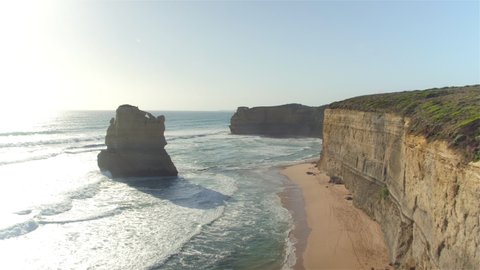DRONE: Picturesque aerial shot of limestone cliffs and promontories at a rugged rocky coast in Victoria, Australia. Endless ocean waves roll towards the famous 12 Apostles shore on a sunny summer day.