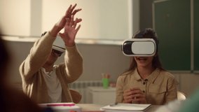 Smiling pupils using 3d vr glasses in school classroom. Multi ethnic students immersing in virtual reality during lesson in modern school. Happy kids in vr headsets having fun in school class - Powered by Shutterstock - Get 15% off with code: PIKWIZARD15