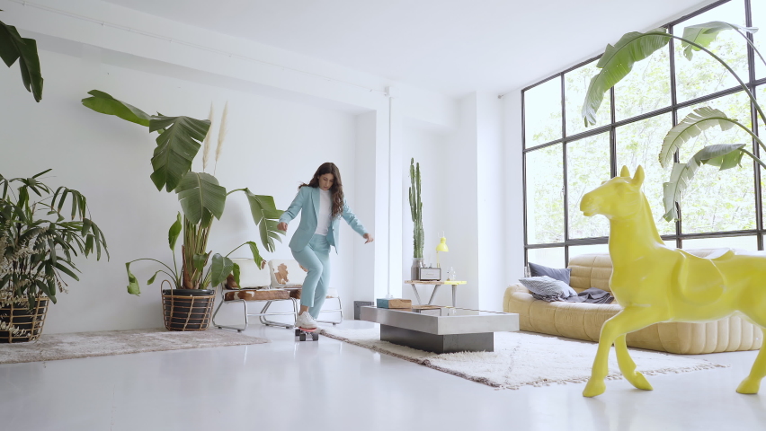 Businesswoman works at home. Office worker taking a break, skating wildly around the office. Funny video of motivated working woman.