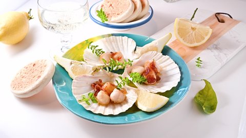 fried scallop, healthy gourmet food, seared scallops with caviar on on a beautiful dish in shellfish shells. A traditional dish of france and italy sea food. 