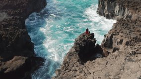 Ponta da Ferraria, Sao Miguel Island, Azores, Portugal. Aerial view of the man climbing onto a steep rock. Astonishing scenery of beautiful natural landscape. High quality 4k footage