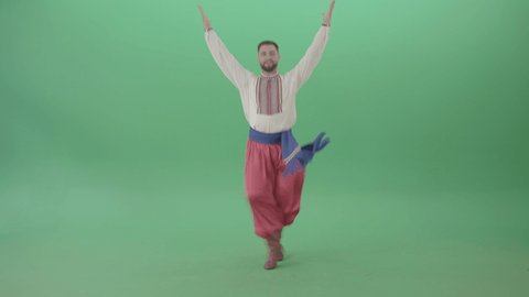 Ukraine Hopak folk dance by UA Cossack Mamai isolated on Green Screen. Handsome guy in authentic Ukrainian man clothes performing traditional hopak dance. 