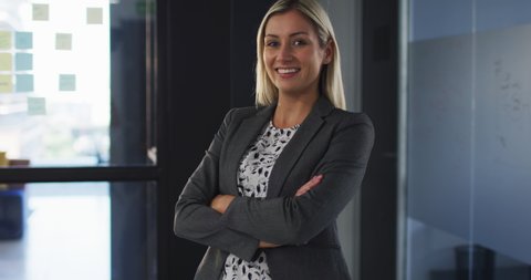 Portrait of caucasian businesswoman with arms crossed smiling looking at camera. work at an independent creative business.