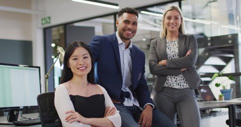 Portrait of group of diverse businesspeople with arms crossed smiling looking at camera. work at an independent creative business.
