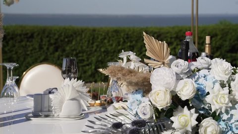 Wedding decorations with flowers, balloons and feathers on the background of the sea. Table for the bride and groom