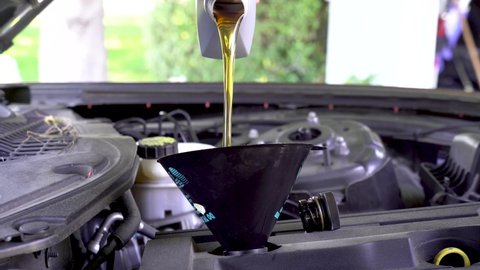 Car Mechanic Pouring Oil during Oil Change