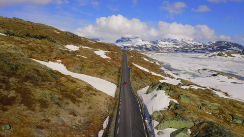 Aerial View Of Car On Road At Mountain In Winter, Drone Flying Backward Over Landscape - Sognefjellsvegen, Norway