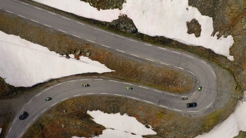 Aerial Lockdown Shot Of Vehicles Moving On Mountain Road During Winter - Sognefjellsvegen, Norway