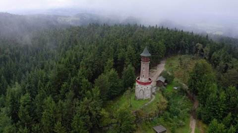 Aerial Panning Beautiful Shot Of Church Over Mountain, Drone Flying Over Green Trees Against Cloudy Sky - Baltic Sea, Poland