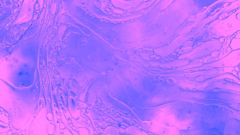 Colorful oil drops floating on water surface, top view. Fantastic abstract background. Bright bubbles moving and spreading. Close up 4k video of weird liquid structures. Scientific chemical experiment