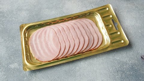 Pork ham in thin slices in a vacuum package put on the table. Meat sliced carbonate in a package for long-term storage.