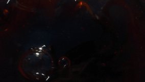 Super slow motion closeup of cola drink splashing with bubbles, drops and foam
