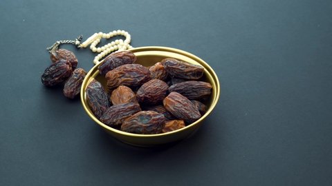 Date Fruit and Rosary on Black Background. Rotating on Turn Table. Iftar Food Mostly Eating in Ramadan. 4K Resolution.
