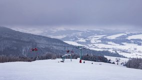 Ski lift, skiers and snowboarders. Winter in Carpatian mountains, ski resort landscape, UHD 4K timelapse video