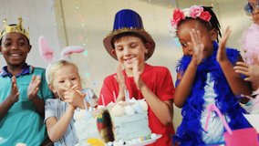 Animation of gold confetti over diverse happy children with hats and birthday cake at party. celebration, birthday, party, childhood and event concept digitally generated video.