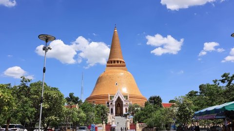 Nakhon Pathom, Thailand - 04 July, 2021: Time lapse of Sky clouds and Big pagoda at Phra Pathom Chedi is the tallest stupa in Thailand.
