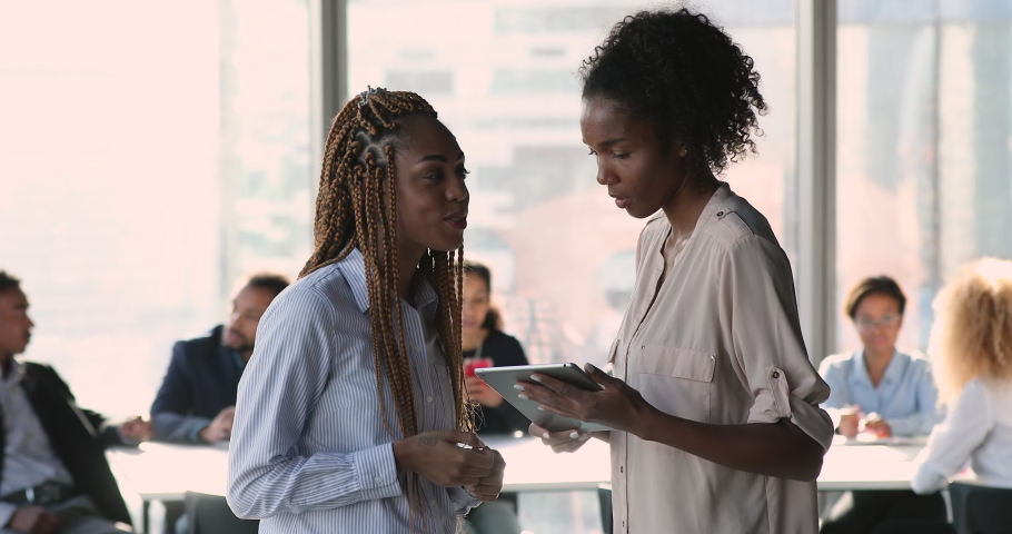 Happy young beautiful female african american ethnicity employees colleagues discussing business project ideas, shaking hands making agreement, celebrating professional achievement at office meeting. Royalty-Free Stock Footage #1075330043