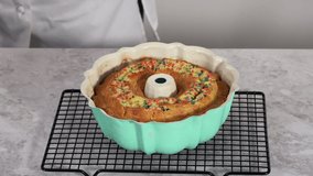 Time lapse. Removing freshly baked funfettti bundt cake from the bundt cake pan.