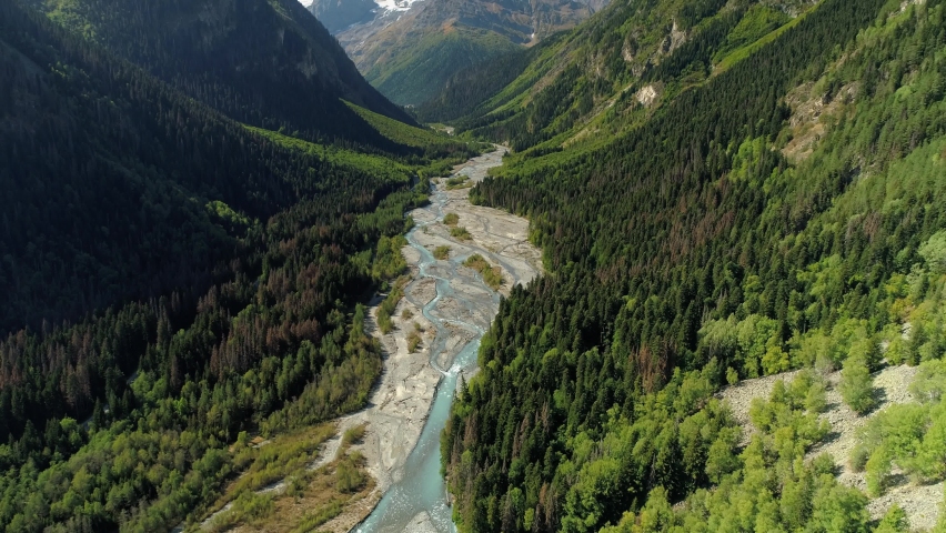From great height epic Dombay best Russia incredible natural landscape mountains sharp peak, alpine glacial river channels among gorge canyon. Summer sunny green slopes. Travel by helicopter rise Royalty-Free Stock Footage #1075348733