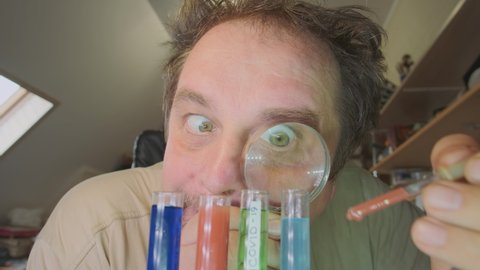 Funny man scientist in laboratory with test tubes makes experiments while developing vaccine against coronavirus infection covid-19.