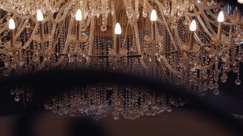 A huge crystal chandelier on the ceiling in a palace or hotel