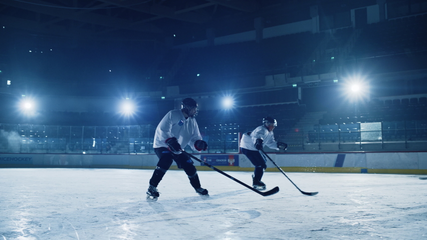 Ice Hockey Rink Arena: Professional Forward Player Breaks Defense, Hitting Puck with Stick Scores Goal, Goalie Missed it. Team Celebrates Victory. Cinematic Slow Motion Tracking Wide Shot | Shutterstock HD Video #1075356548