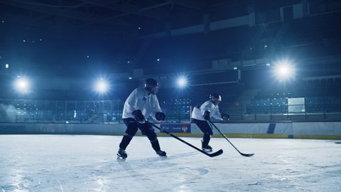 Ice Hockey Rink Arena: Professional Forward Player Breaks Defense, Hitting Puck with Stick Scores Goal, Goalie Missed it. Team Celebrates Victory. Cinematic Slow Motion Tracking Wide Shot