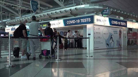 PORTO, PORTUGAL – 16 JUNE 2021: Airline passengers wearing face masks line up for Covid-19 coronavirus test at Porto airport, international travel during global pandemic
