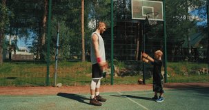 Basketball players exercising before workout. Sportive family father and son training on basketball court 
