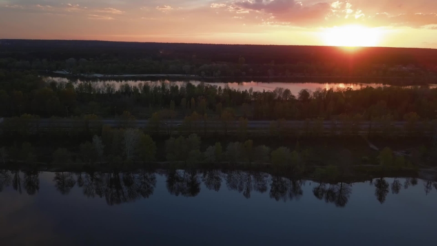 Colorful sunset over the road with cars overlooking the forest and lake Ukraine, Kiev on May 6, 2021.