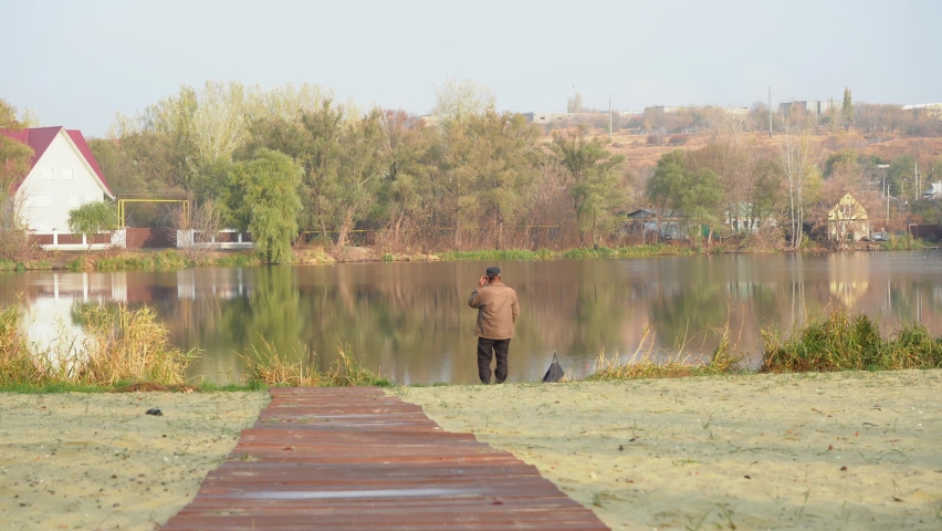 a man fishing while standing by the river