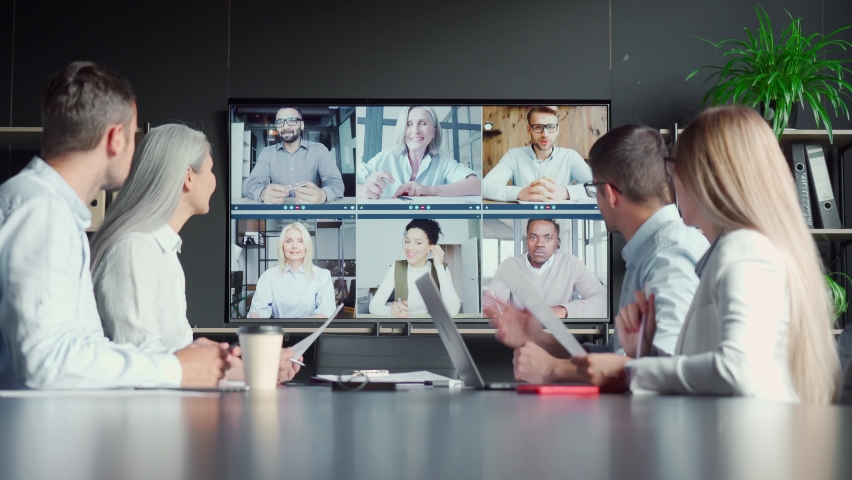 Global corporate online videoconference chat in meeting room with diverse people talking in modern office and multicultural multiethnic colleagues on big screen monitor. Business technologies concept. | Shutterstock HD Video #1075375565