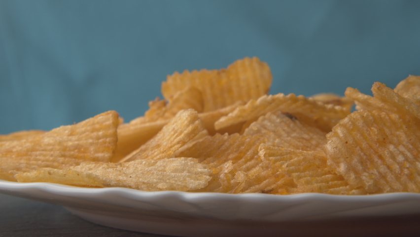 Chips falling on isolated background. Stock footage. Delicious chips fall and cause appetite. Harmful snacks in form of potato chips. Favorite junk food Royalty-Free Stock Footage #1075378775