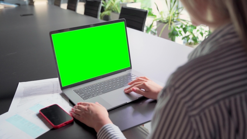 Young Caucasian businesswoman ceo executive manager using typing email letter using laptop computer with empty blank green mockup screen for advertising at desk. Business concept. Over shoulder view. Royalty-Free Stock Footage #1075385969