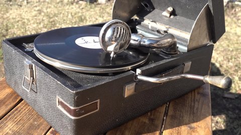 Old vintage retro big black gramophone phonograph outdoor. the vinyl record is spinning. close up view closeup. High quality 4k footage. the inscription in Russian under a beautiful waltz