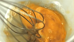Super slow motion raw egg whisk. On a white background.Filmed on a high-speed camera at 1000 fps. High quality FullHD footage