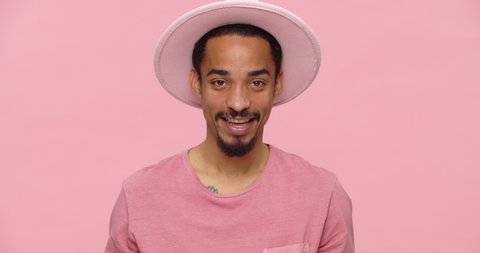Rude black bearded man showing middle fingers and smiling isolated over pink