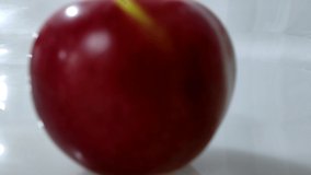 Delicious beautiful red apple on a white background, video with the effect of distance and zoom. Red apple on a white background zoom out motion.