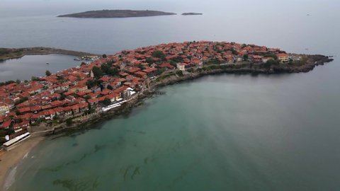 View in a circle from the air to the beach, the port and the town of Sozopol, while there are small waves 