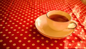 Aesthetic Shot Of Steaming Blue Striped White Tea Cup Filled With Herbal Tea On Matching Plate. Spotty Red Table Cloth Under Them. - Powered by Shutterstock - Get 15% off with code: PIKWIZARD15