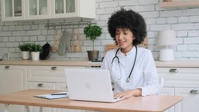 Afro american woman doctor uses laptop during online consultation at home. Family Doctor, Patient Support, Help at Home, Caring for the Sick.