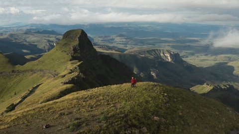 Aerial panning view of tourists standing ontop of the spectacular Drakensberg mountains, KwaZulu-Natal,South Africa