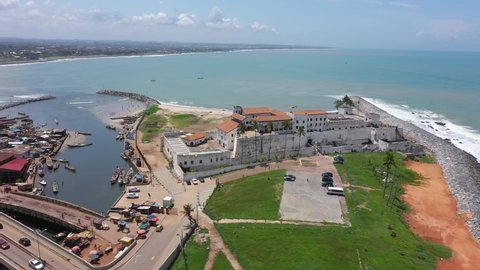 ELMINA, GHANA - 29 JUN 2021: Aerial Elmina Castle Ghana Africa fast motion circle. West Africa on Atlantic ocean. Erected by Portuguese in 1482. Over 500 years Historic slave trade on Gold Coast. 