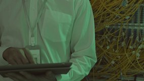 Tilting up POV of male Caucasian engineer wearing white shirt, using tablet computer, then looking up and smiling on camera, standing in data center room - Powered by Shutterstock - Get 15% off with code: PIKWIZARD15