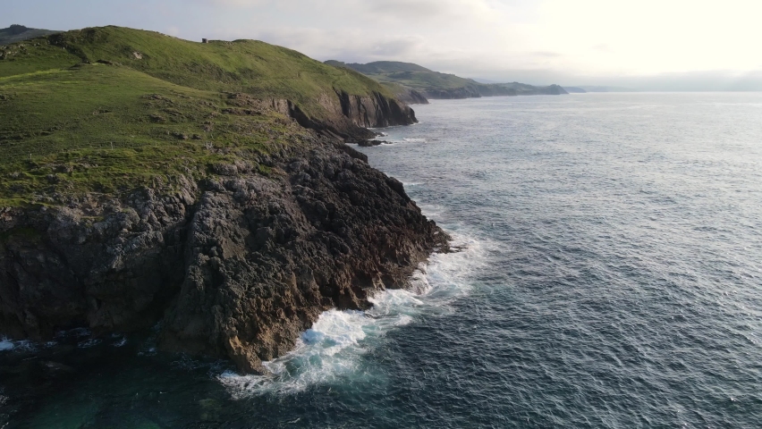 Fisherman fishing off the cliffs with rough seas.