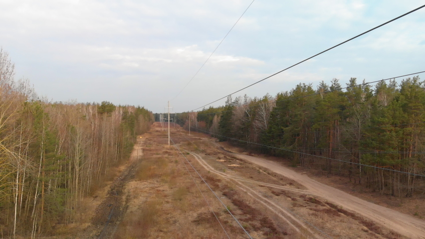 Near the wires of the power line in the forest. Concept of communication and electrification of remote regions. Wide angle shot