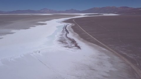 Aerial view over endless dried desolate land on blurred mountain range in the horizon - Maricunga Salt flat plateau near San Pedro de Atacama, Chile.