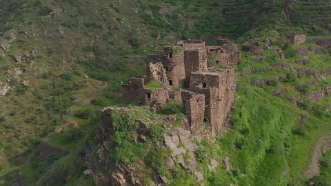 An old stone lookout fort amongst the houses built on the sides of the mountains in the historical Faifa region of Saudi Arabia (aerial view) Al Dayer Jizan Region, Saudi Arabia.