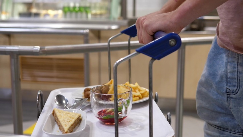 Visitor with a tray at a self-service cafe or buffet restaurant. Hotel food choices during covid-19 quarantine restrictions