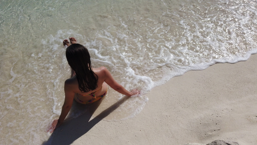 girl in a swimsuit sits on the beach. Turquoise water, Cancun